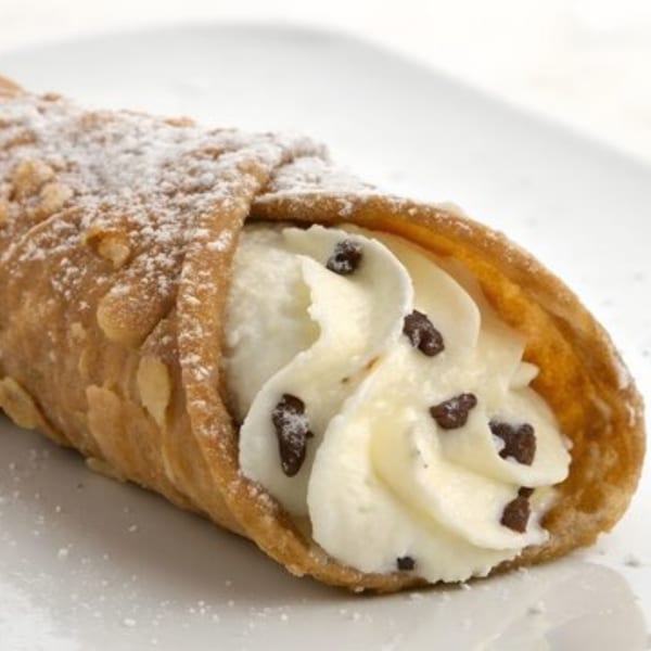 A Tony's at Brentwood cannoli, filled with creamy ricotta and chocolate chips, dusted with powdered sugar.